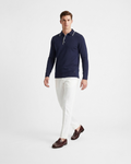 Polo maniche lunghe uomo in maglia di cotone blu con dettagli colletto con righe bianche indossata su sfondo bianco