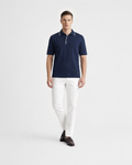 Polo uomo in maglia di cotone blu con dettagli colletto con righe bianche indossata su sfondo bianco