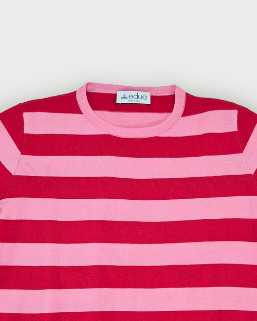 Dettaglio girocollo maglia donna in cotone a righe rosse e rosa su sfondo bianco