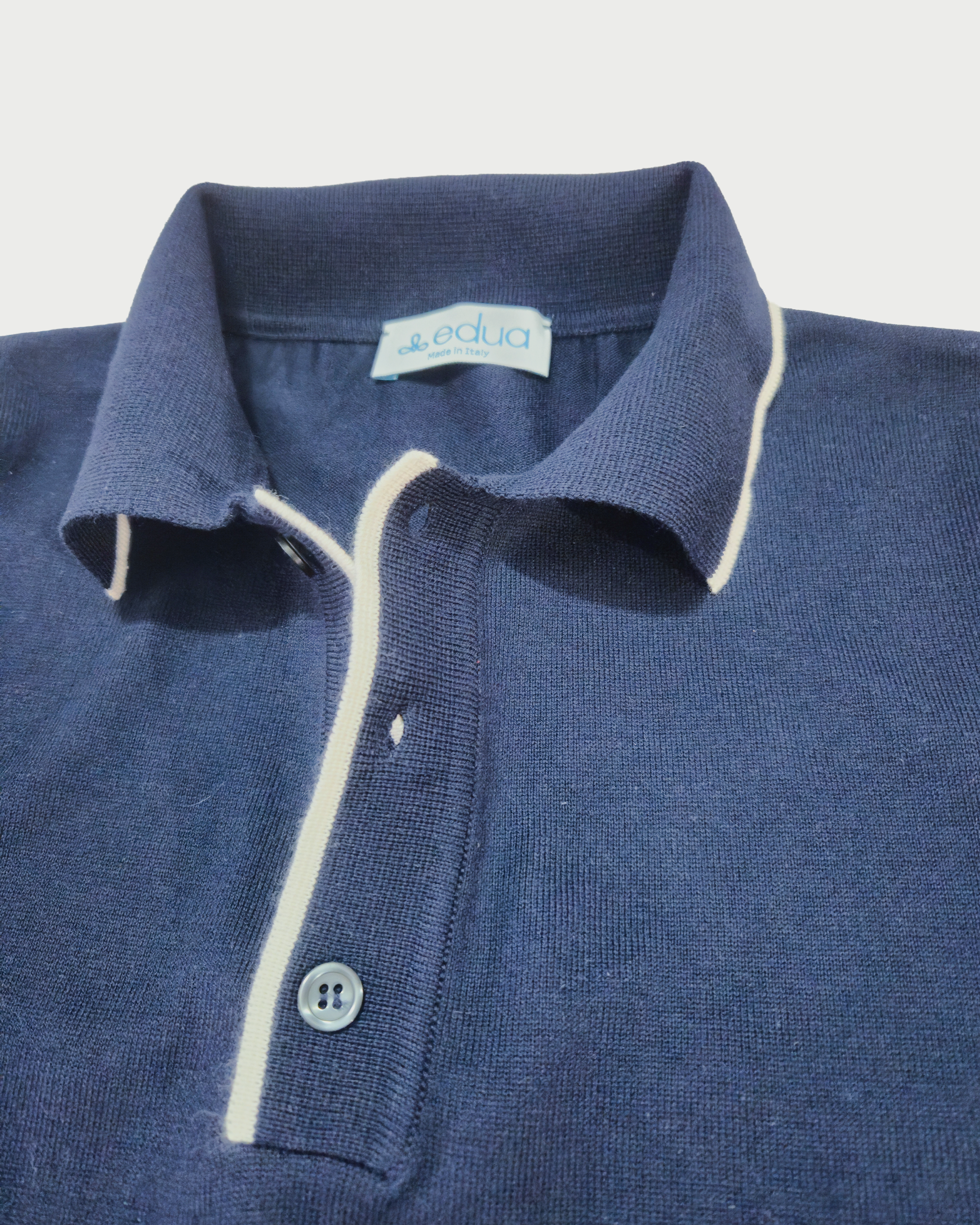 dettagli colletto Polo uomo in maglia di cotone blu su sfondo bianco