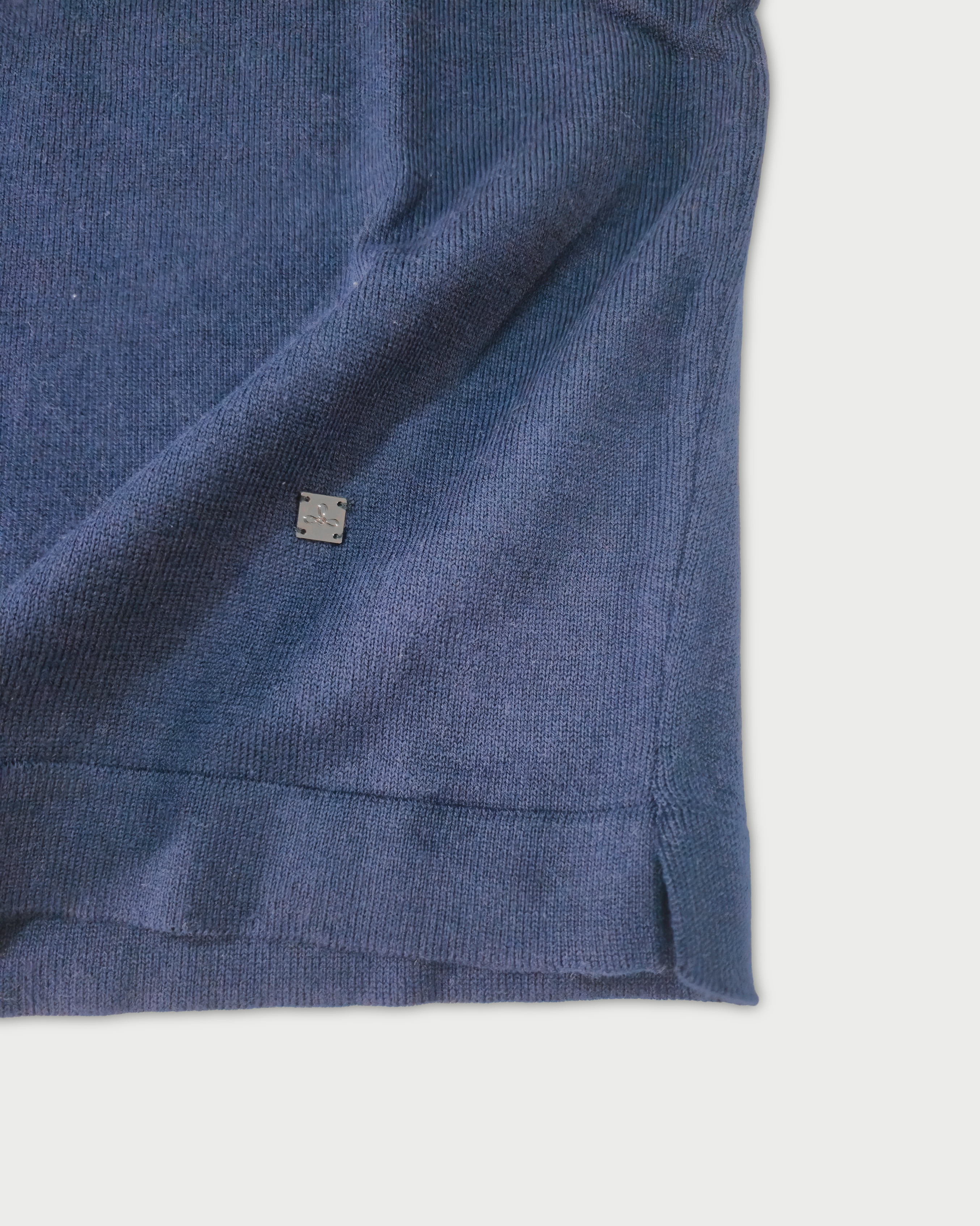 Dettaglio fondo e logo Edua polo maniche lunghe uomo in maglia di cotone blu su sfondo bianco