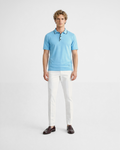 Polo uomo in maglia di cotone celeste con dettagli colletto con righe blu indossata su sfondo bianco