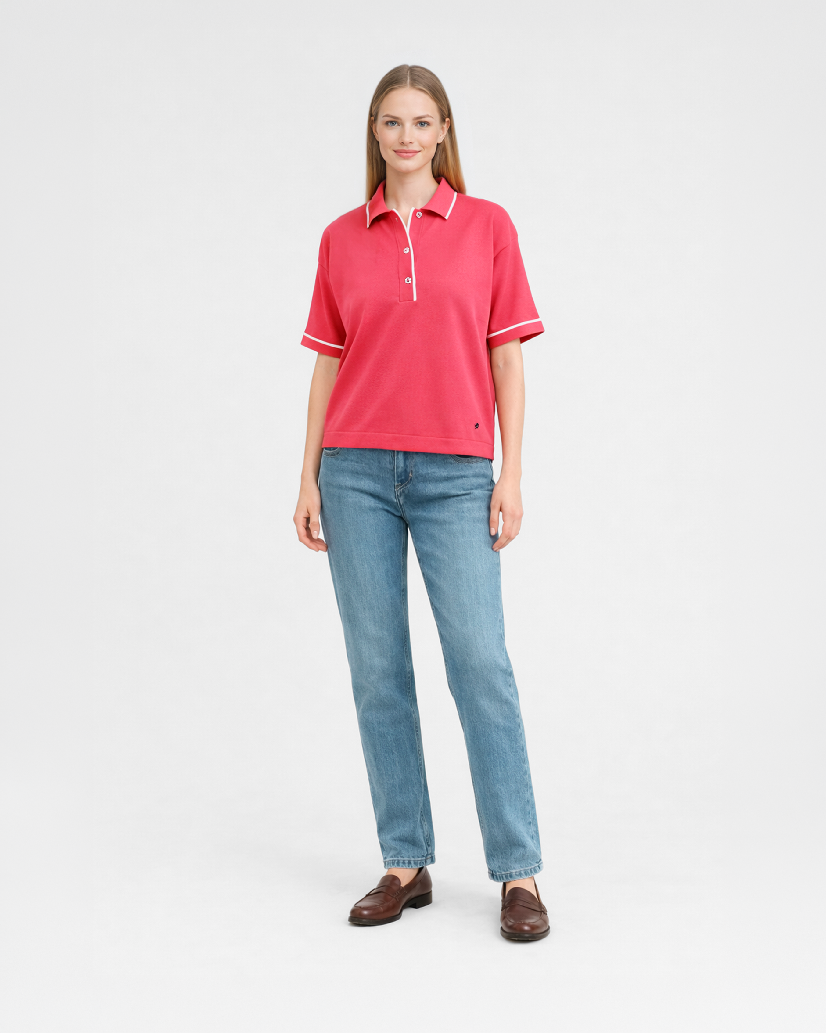 Polo donna over in maglia di cotone rosa corallo con colletto e bordi bianchi indossata su sfondo bianco