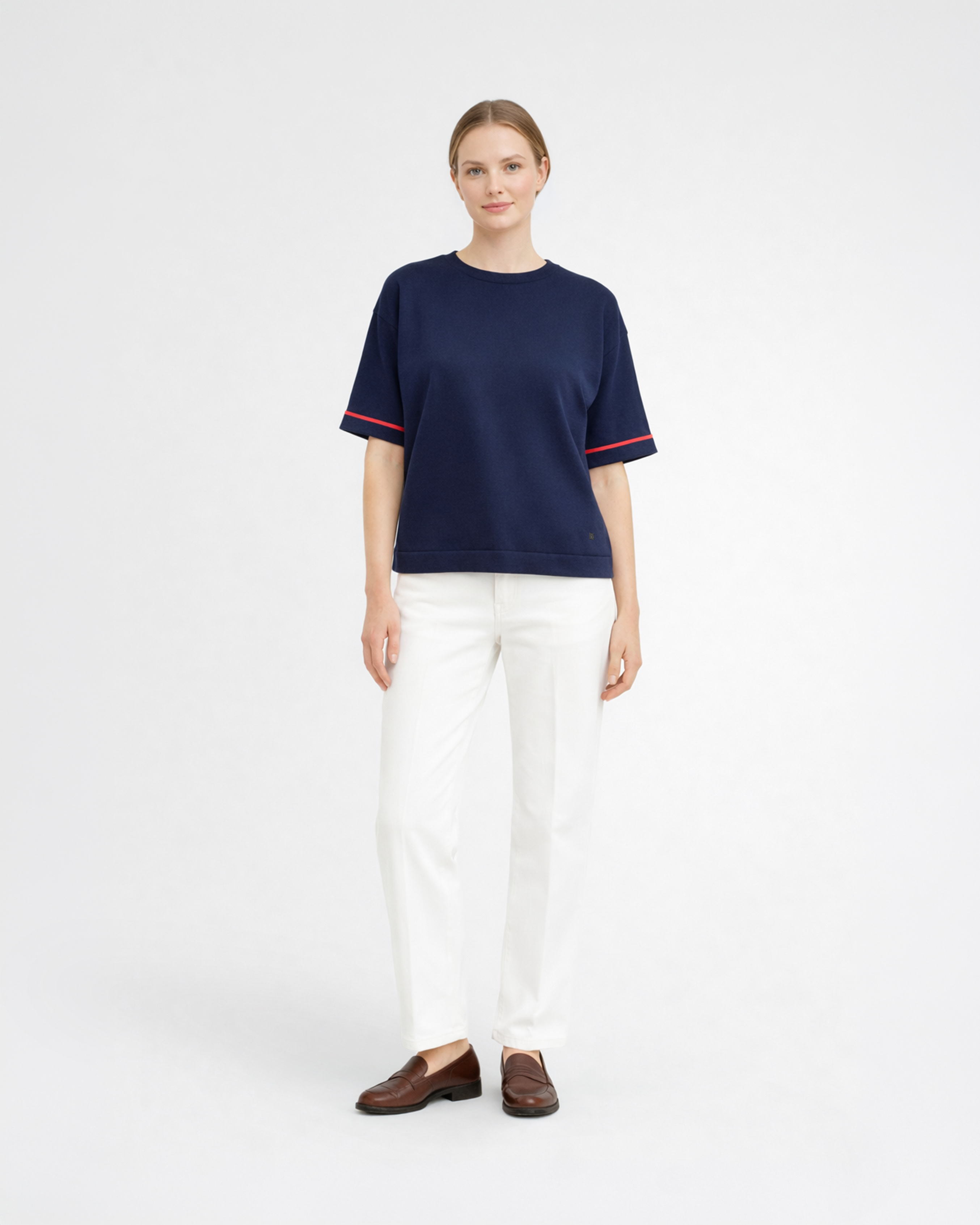Maglia donna in maglia di cotone blu con girocollo e profili rossi sulle maniche indossata su sfondo bianco